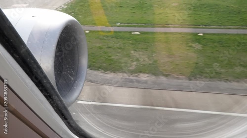 Airplane engine view from window during landing on the runway during commercial air travel and tourism