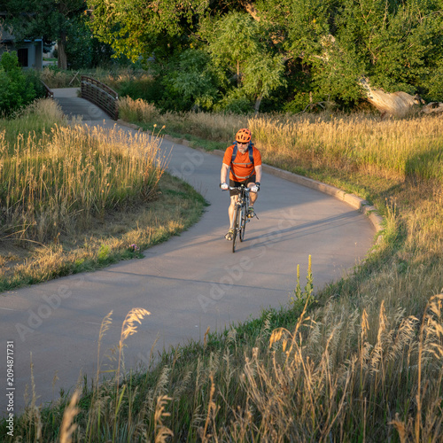 Senior male cyclist is commuting on a bike trail in Fort Collins in northern Colorado, late summer scenery