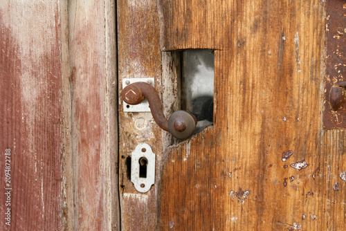 Old wooden door with rusty metal handle in Beaune France