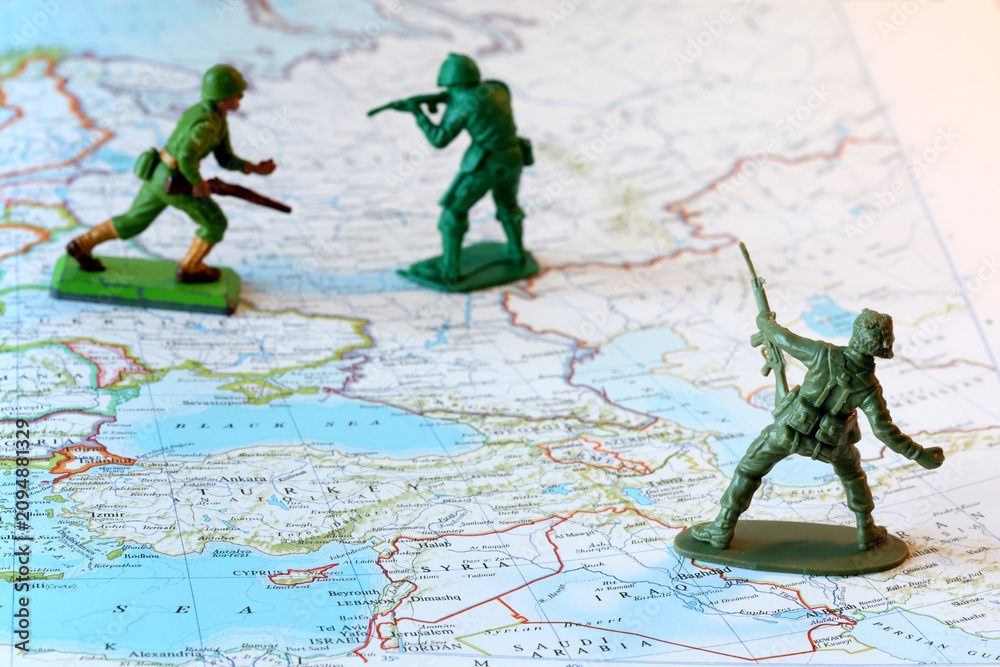Fototapeta premium Miniature Soldiers Facing Off Over Ukraine and the Middle East on top of a World Map