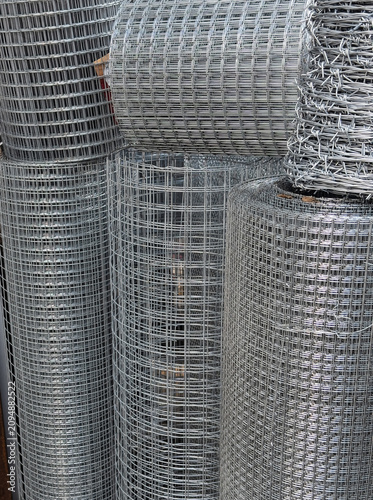 Rolls of galvanized welded wire mesh stacked in warehouse
