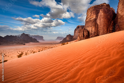 Foto Wadi Rum desert landscape with red sand dunes and sandstone cliffs under dramati