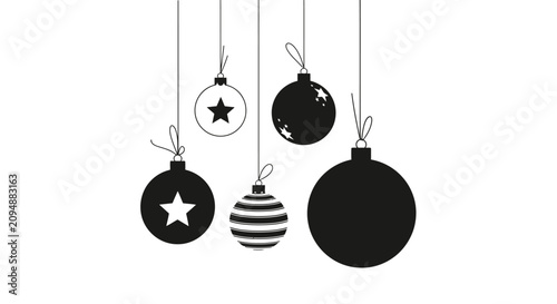 Black and white christmas ornaments hanging on strings with suspended strings against plain white background five black decorations spherical