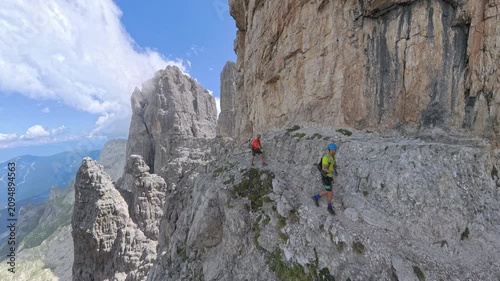 Wide panoramic view of hikers on Via Ferrata Bocchette Centrali below Campanile Alto, Brenta Dolomites
