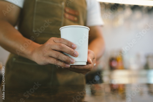 Foto Barista serving a freshly crafted latte with elegant latte art, offering a warm specialty coffee experience in a cozy café