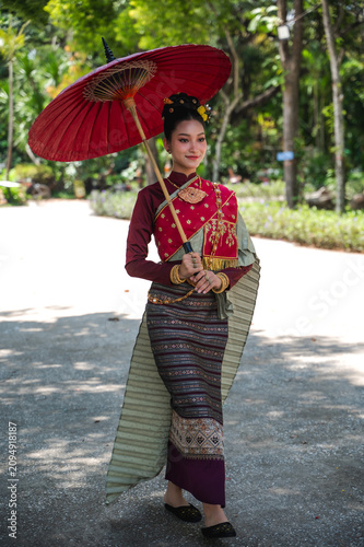 Foto Graceful young Thai woman in a stunning traditional silk Chakkraphat costume wit