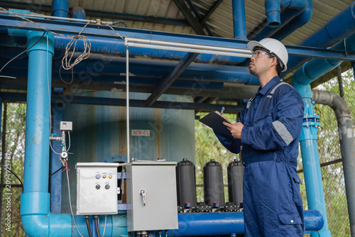 Fotografi Professional engineer performing maintenance inspection of industrial water filtration system with multiple membrane units