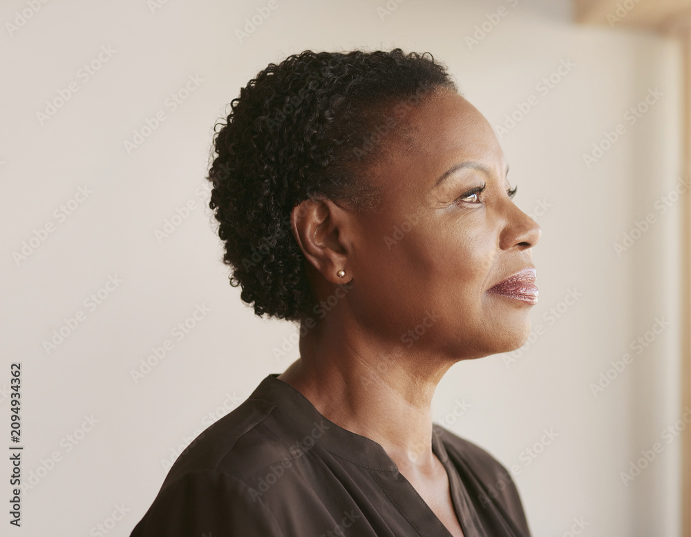 Obraz premium Thoughtful Mature 50s, 40s, Black Woman in Side Profile in a Minimal Interior
