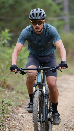 Man cycling mountain bike on forest trail
