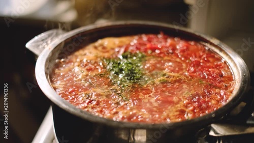 Traditional Ukrainian borscht soup with fresh dill in a metal pot cooking close up