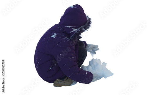 Isolated on white background. A little girl is making a snowball out of snow. The girl is sitting.