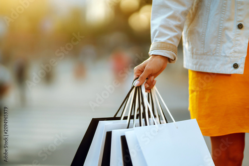 Fotografía Close up of a woman holding colorful shopping bags outdoors, consumer lifestyle and retail