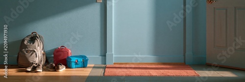 Backpack, lunch box, and shoes placed against a blue wall in a hallway, back to school banner