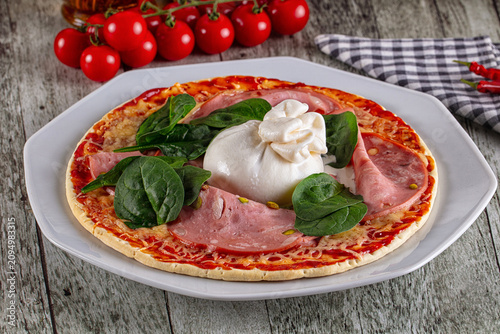 Mini pizza with ham spinach and burrata cheese on rustic wood table