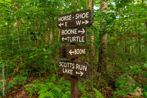 Wooden trail sign marking hiking routes through the forest at French Creek State Park, Pennsylvania.