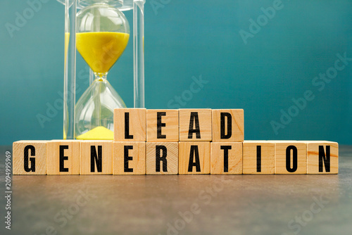 Yellow hourglass behind wooden blocks spelling LEAD GENERATION, symbolizing customer acquisition, marketing strategy, sales funnel, business growth, and lead management.