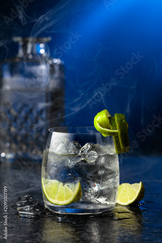 Fotografía Vodka with lime and ice cubes in a fogged up glass.