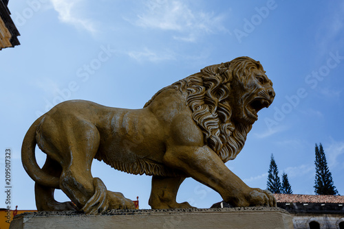 Tableau sur toile Stone statue of a growling, fierce lion in the town of Leon Nicaragua