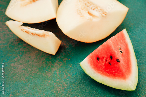 Canvastavla Sliced pieces of watermelon and melon on a green surface in a kitchen setting at