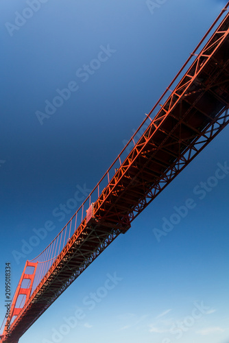Fotografi Golden Gate Bridge towers above sailors