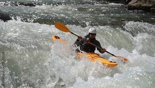 Man Paddles a Kayak Through Whitewater Rapids in a River During Daytime