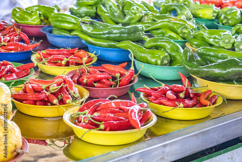 Foto Fresh Red and Green Chili Peppers in Colorful Bowls at a Local Market