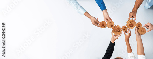 Fotografie A diverse group of hands brings together gears that symbolize collaboration and innovative ideas in a modern business setting, highlighting teamwork and strategic planning