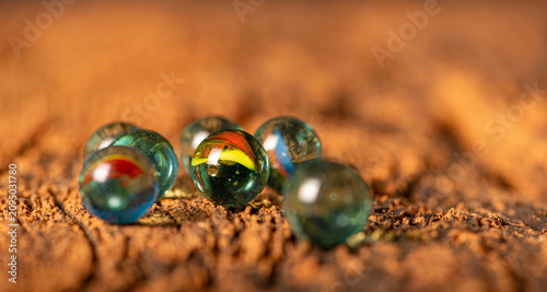 Marbles; beautiful details of marbles placed on a rustic wooden surface, selective focus.