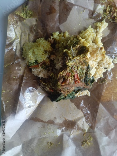 Aftermath of a casual meal, with food scraps and remnants on a crumpled paper wrapper, depicting consumption waste