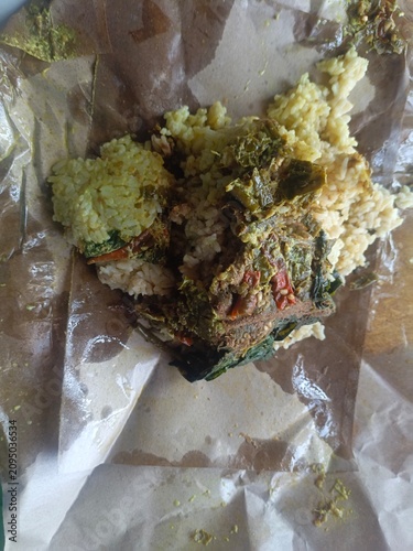 Savory Meal nasi padang Wrapped in Paper.  Indonesian padang food or nasi bungkus with beef rendang, casava leaf, green chili sauce. Semarang, 12-07-2026