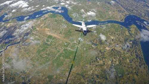 View of Airplane Flying Over Landscape With Rivers and Fields From Above Duri...