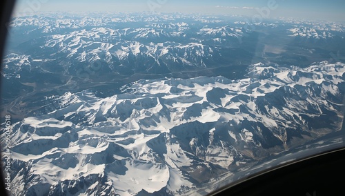 Snowy Mountains View Taken From Airplane During Flight High Above Landscape