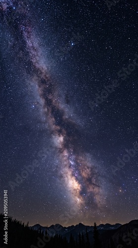 Night sky with Milky Way and stars above mountain landscape  