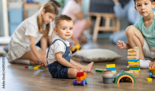 Foto Two boys passionate about game with wooden bricks and car, children toddler, inf