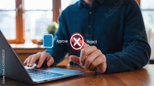 Man sitting at desk with laptop and approval reject icons on screen interface