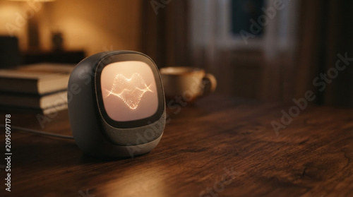 Smart speaker displaying animated heart wave on desktop near books