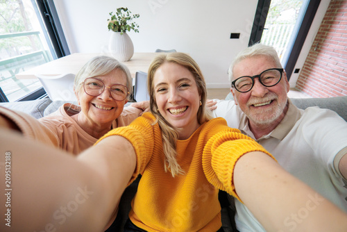 Konstfotografi Young woman, senior father, and senior mother smiling for a selfie, celebrating