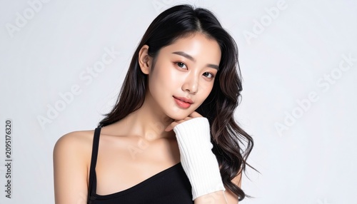 Portrait of a young woman posing in a black top against a white background