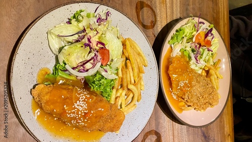 Delicious Meal Featuring Crispy Chicken, Golden Fries, and Fresh Salad on a Rustic Table