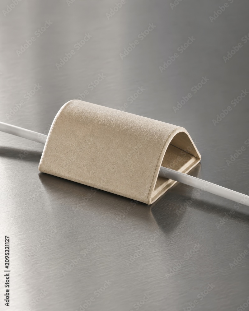 Obraz premium Minimalist cable organizer on metal surface shown as a modern product still life with realistic materials soft cinematic lighting and clean copy space