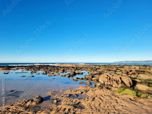 A rock pool at low tide on the rock platform at Susan Gilmore Beach Newcastle New South Wales Australia.