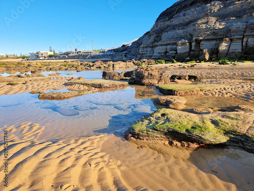 Coastal cliff overlooking Susan Gilmore Beach rock platform Newcastle New South Wales Australia. Taken at low tide