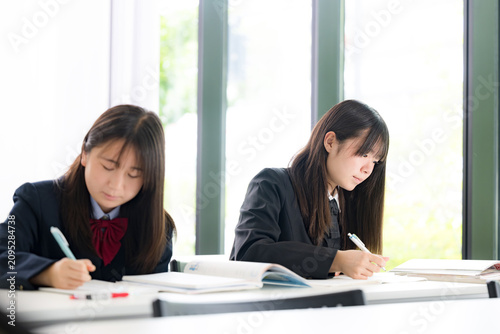 教室や塾で真剣に勉強へ取り組む日本人女子高校生　高校受験、大学受験の勉強や定期テスト対策のイメージ