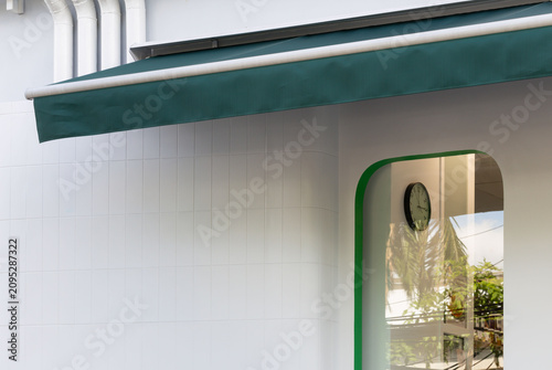 Arched doorway with green frame and hanging clock
