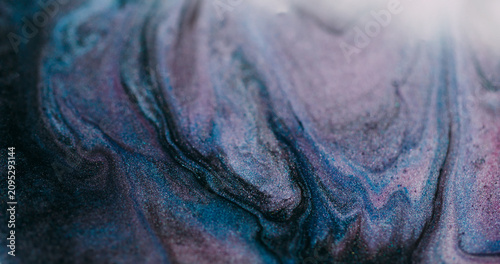 Shimmering fluid blur. Paint stream. Purple blue liquid pigment wave spill with black gray glitter mixing color abstract background.