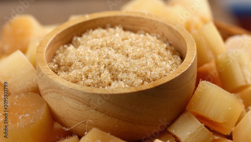 Obraz na płótnie Sugar in a wooden bowl with fresh sugarcane