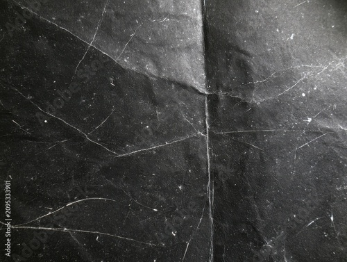 Distressed black paper texture background with white cracks and scratches for antique abstract dark vintage poster backdrop