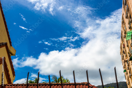 Cloudy sky with airplane contrail behind fence creating dramatic atmosphere Thailand.