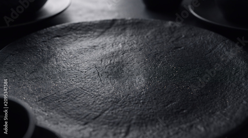 Black stone plate background. Dark textured slate surface for food photography and culinary display.