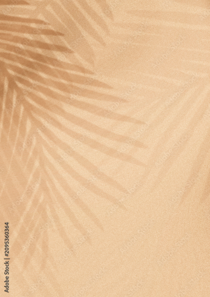 Fototapeta premium Soft beige background with palm leaf shadows creating a tropical vibe.